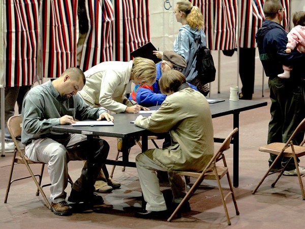 A group of voters fill out their ballots at a table rather than wait for an empty voting booth Tuesday, Nov. 2, 2004, at the Civic Center in Dodge City, Kan. Depending on their precinct, voters had to wait in line to receive a ballot and some had to wait in line for an empty booth. (AP Photo/Dodge City Daily Globe, Michael Schweitzer)