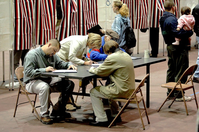 A group of voters fill out their ballots at a table rather than wait for an empty voting booth Tuesday, Nov. 2, 2004, at the Civic Center in Dodge City, Kan. Depending on their precinct, voters had to wait in line to receive a ballot and some had to wait in line for an empty booth. (AP Photo/Dodge City Daily Globe, Michael Schweitzer)