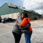 Franlisa Smith, whose son Nick Smith is a defensive lineman on the Mosley High football team, hugs defensive line coach William Mosley at the start of practice at the school, which was heavily damaged from Hurricane Michael, in Lynn Haven, Fla., Friday, Oct. 19, 2018. (AP Photo/Gerald Herbert)