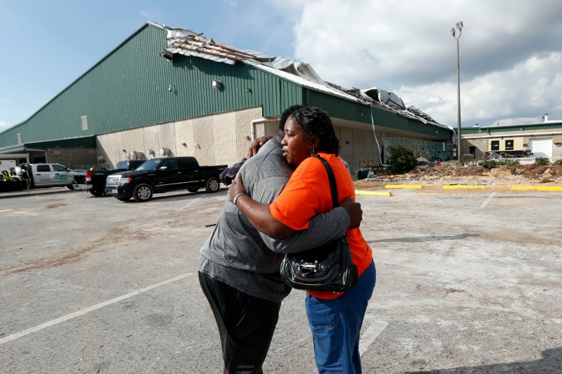 Franlisa Smith, whose son Nick Smith is a defensive lineman on the Mosley High football team, hugs defensive line coach William Mosley at the start of practice at the school, which was heavily damaged from Hurricane Michael, in Lynn Haven, Fla., Friday, Oct. 19, 2018. (AP Photo/Gerald Herbert)