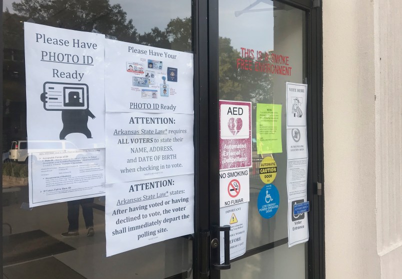 A sign outside the Pulaski County Regional Building in Little Rock, Ark., advises voters on Monday, Oct. 22, 2018, of a state law requiring them to show photo identification before casting a ballot. Early voting began Monday for Arkansas' November 6 midterm election. (AP Photo/Andrew DeMillo)