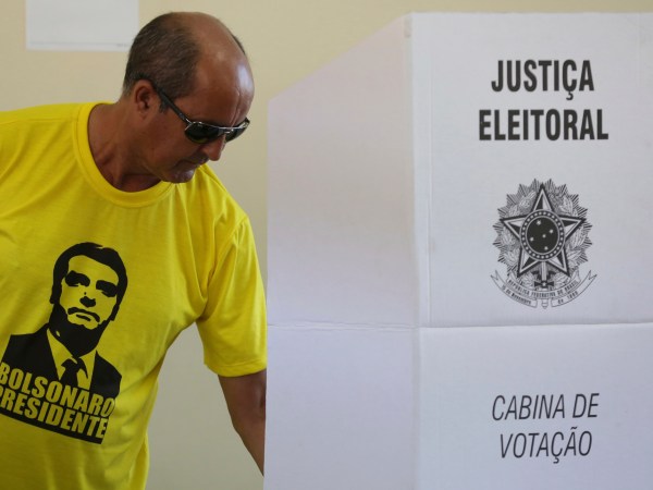 A voter dressed in a shirt with the image of the right-wing presidential candidate Jair Bolsonaro, vote in a polling station in a suburb of Brasilia, Brazil, Sunday, Oct. 28, 2018. Brazil holds today the second round of general elections. (AP Photo/Eraldo Peres)