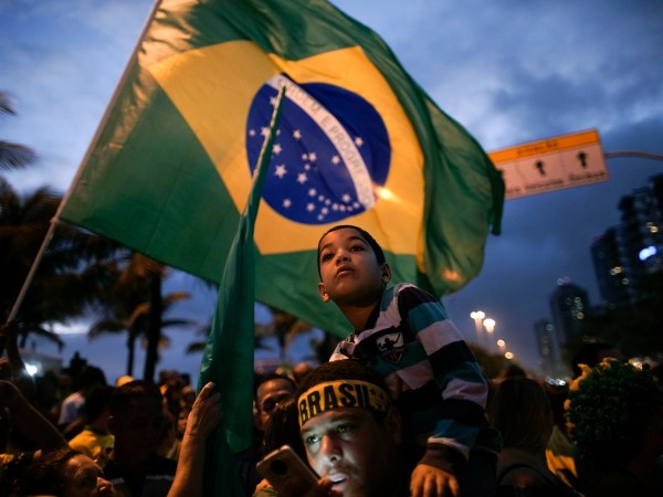 Supporters stand with is kid on the shoulders as he wait for the speech of Jair Bolsonaro in front of his residence in Rio de Janeiro, Brazil, Sunday, Oct. 28, 2018. Brazil’s Supreme Electoral Tribunal declared the far-right congressman the next president of Latin America’s biggest country. (AP Photo/Leo Correa)