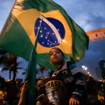 Supporters stand with is kid on the shoulders as he wait for the speech of Jair Bolsonaro in front of his residence in Rio de Janeiro, Brazil, Sunday, Oct. 28, 2018. Brazil’s Supreme Electoral Tribunal declared the far-right congressman the next president of Latin America’s biggest country. (AP Photo/Leo Correa)