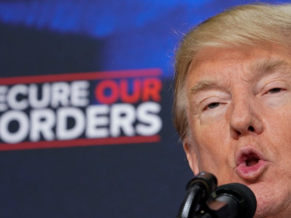 US President Donald Trump speaks on immigration in the South Court Auditorium, next to the White House on June 22, 2018 in Washington, DC, next to people holding posters of victims allegedly killed by illegal immigrants. (Photo by Mandel NGAN / AFP)        (Photo credit should read MANDEL NGAN/AFP/Getty Images)