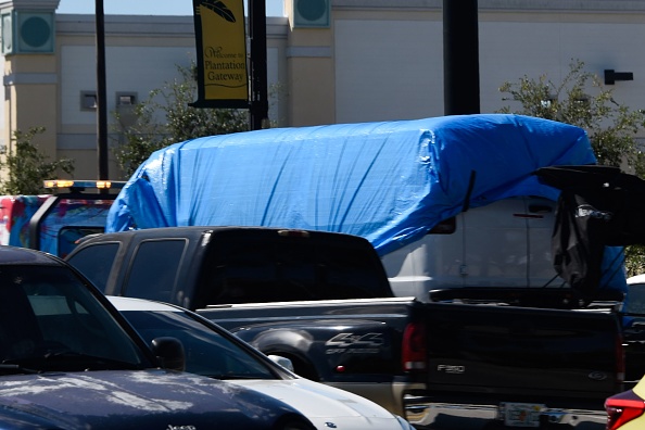 A van covered in blue tarp is towed by FBI investigators on October 26, 2018, in Plantation, Florida, in connection with the 12 pipe bombs and suspicious packages mailed to top Democrats. - A suspect identified by investigators as Cesar Sayoc, 56, was arrested near an Auto store in Plantation. (Photo by Michele Eve Sandberg / AFP)        (Photo credit should read MICHELE EVE SANDBERG/AFP/Getty Images)