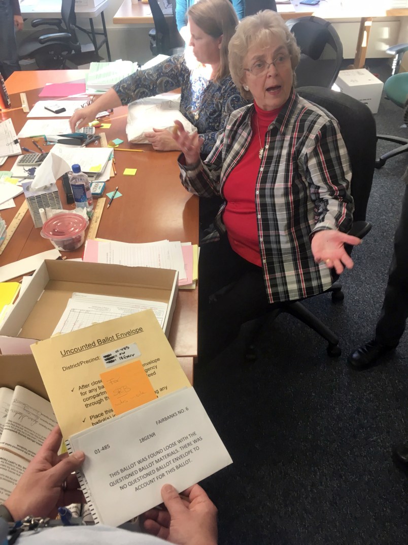 This Nov. 23, 2018 photo shows Alaska State Review Board ballot examiner Stuart Sliter reacting when a loose ballot from a tied state House race is found without an envelope in Juneau, Alaska. Officials are investigating the origin of the ballot and will decide by Friday, Nov. 30, 2018, whether to count it during a recount of the Fairbanks House District 1 race. (James Brooks/Anchorage Daily News via AP)