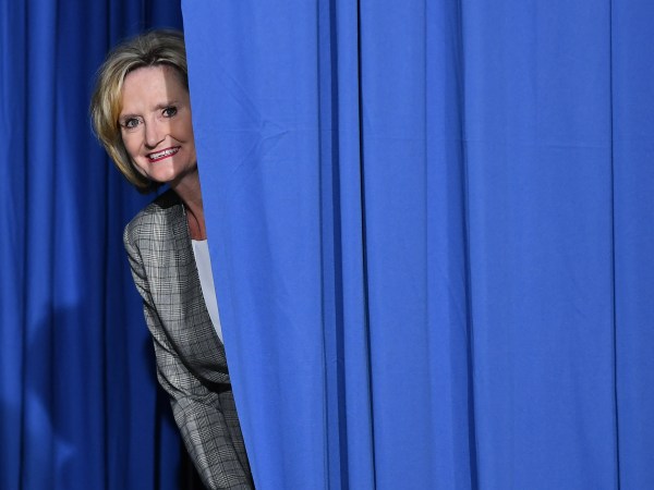 Senator Cindy Hyde-Smith peaks out from behind a curtain before a rally with US President Donald Trump at  Landers Center √ê Arena in Southaven, Mississippi, on October 2, 2018. (Photo by MANDEL NGAN / AFP)        (Photo credit should read MANDEL NGAN/AFP/Getty Images)