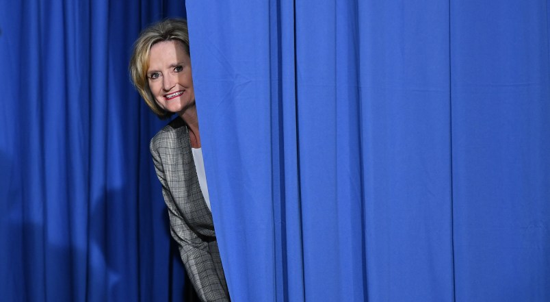 Senator Cindy Hyde-Smith peaks out from behind a curtain before a rally with US President Donald Trump at  Landers Center √ê Arena in Southaven, Mississippi, on October 2, 2018. (Photo by MANDEL NGAN / AFP)        (Photo credit should read MANDEL NGAN/AFP/Getty Images)