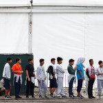 Immigrant boys walk in a line at the Homestead Temporary Shelter for Unaccompanied Children a former Job Corps site that now houses them Monday, Dec. 10, 2018, in Homestead, Fla. (AP Photo/Brynn Anderson)