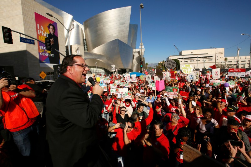 United Teachers Los Angeles president, Alex Caputo-Pearl addresses thousands of teachers who may go on strike against the nation's second-largest school district next month, as they rally next to the Walt Disney Concert Hall downtown Los Angeles Saturday, Dec. 15, 2018. The union contends that the district is hoarding a huge financial reserve that could be used to pay teachers more and improve conditions for students. Union leaders also criticized a plan to reorganize the district by dividing it into 32 networks. Saturday’s march ended at the Broad Museum to highlight the role billionaires like Eli Broad have by funding the corporate charter industry and privatization efforts. (AP Photo/Damian Dovarganes)