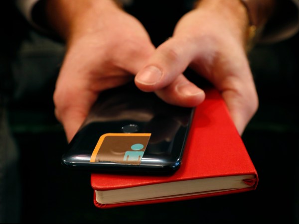 HOLD FOR STORY BY RAPHAEL SATTER - John Scott-Railton, a senior researcher at Citizen Lab, holds his cell phone, whose camera is blocked by an adhesive sticker, as he psoes for a photograph, Thursday, Jan. 17, 2019, in New York. Citizen Lab research includes investigating digital espionage, documenting Internet filtering and other technologies and practices that impact freedom of expression online. But recently Scott-Railton believes he has become a target, hence the extra protection. (AP Photo/Kathy Willens)