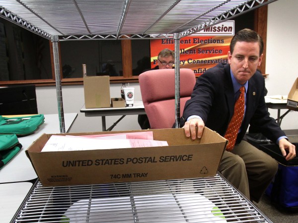 Seminole County, Fla., Elections Supervisor Michael Ertel grabs a box of ballots during the count of 600 provisional ballots, in Sanford, Florida, Thursday, November 8, 2012. In background, Richard Siwica, counsel for Mike Clelland, the challenger that is currently leading incumbent Chris Dorworth, looks on. (Joe Burbank/Orlando Sentinel/MCT)