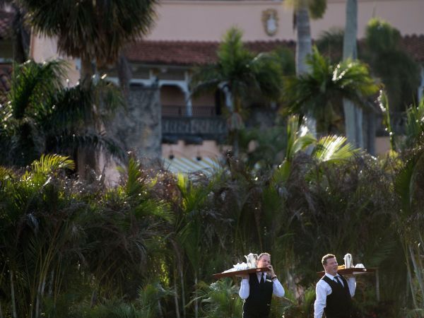 Staff carry trays of coffee at Mar-a-Lago while US President Donald Trump visits his property March 24, 2018 in Palm Beach, Florida. / AFP PHOTO / Brendan Smialowski        (Photo credit should read BRENDAN SMIALOWSKI/AFP/Getty Images)