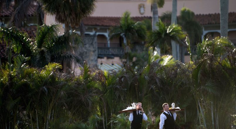 Staff carry trays of coffee at Mar-a-Lago while US President Donald Trump visits his property March 24, 2018 in Palm Beach, Florida. / AFP PHOTO / Brendan Smialowski        (Photo credit should read BRENDAN SMIALOWSKI/AFP/Getty Images)