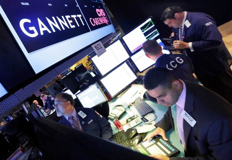 FILE - In this Aug. 5, 2014, file photo, specialist Michael Cacace, foreground right, works at the post that handles Gannett on the floor of the New York Stock Exchange.  Gannett is walking away from its takeover attempt at Tronc, the publisher of the Los Angeles Times, Chicago Tribune and other major dailies. Shares of Gannett Co., publisher of USA Today, are surging more than 8 percent in premarket trading Tuesday, Nov. 1, 2016.  (AP Photo/Richard Drew, File)