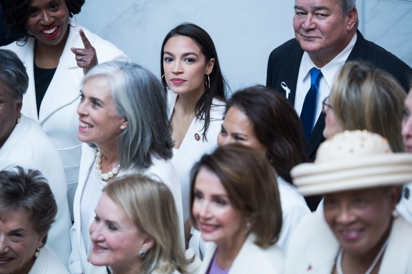 UNITED STATES - FEBRUARY 05: Rep. Alexandria Ocasio-Cortez, D-N.Y., top center, and Speaker Nancy Pelosi, D-Calif., bottom center, pose for a group photo of House Democrats in the Capitol Visitor Center, who plan to wear "suffragette white" to the State of the Union address to show solidarity for women's agendas on Tuesday, February 5, 2019. (Photo By Tom Williams/CQ Roll Call)