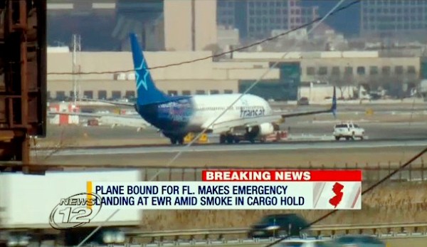 In this image taken from video provided by News12 New Jersey, Air Transat Flight 942 is towed along the runway at Newark Liberty International Airport, Saturday, March 9, 2019 in Newark NJ. The Boeing 737 with 189 passengers aboard made an emergency landing after a possible fire in the cargo hold was reported. Two passengers suffered minor injuries. No fire was found and the cause of the smoke remains under investigation. (News12 New Jersey via AP)