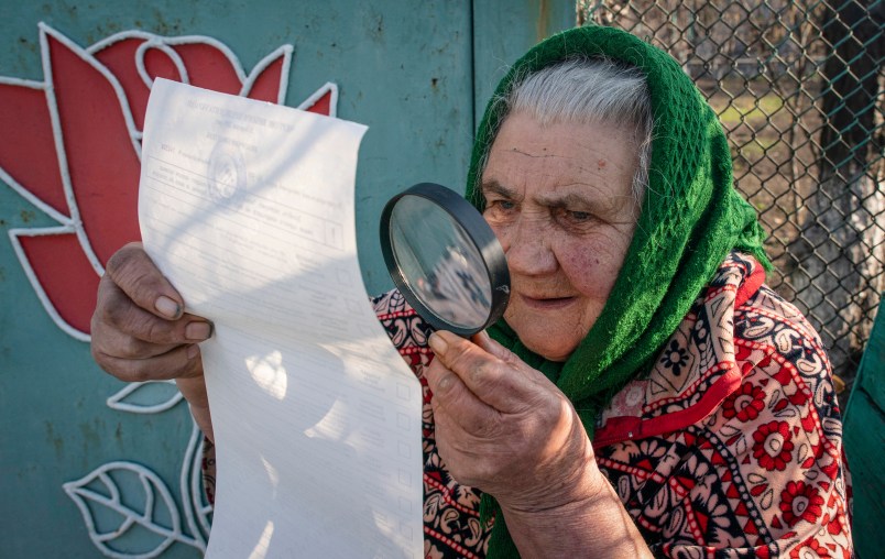 An elderly woman examines her ballot voting at home during the president elections in Mariinka, near a contact line not far from Donetsk, eastern Ukraine, Sunday, March 31, 2019. Ukrainians choose from among 39 candidates for a president they hope can guide the country of more than 42 million out of troubles including endemic corruption, a seemingly intractable conflict with Russia-backed separatists in the country's east and a struggling economy. (AP Photo/Evgeniy Maloletka)