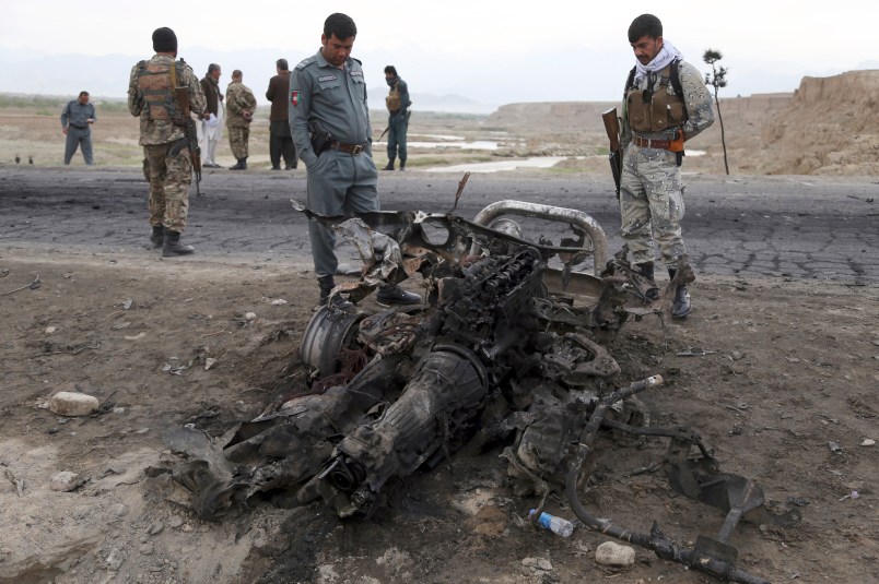 Afghan security forces gather at the site a day after an a Suicide attack near the Bagram Air Base, north of Kabul, Afghanistan, Tuesday, April 10, 2019. Three American service members and a U.S. contractor were killed when their convoy hit a roadside bomb on Monday near the main U.S. base in Afghanistan, the U.S. forces said. The Taliban claimed responsibility for the attack. (AP Photo/Rahmat Gul)