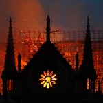 Flames and smoke rise from Notre Dame cathedral as it burns in Paris, Monday, April 15, 2019. Massive plumes of yellow brown smoke is filling the air above Notre Dame Cathedral and ash is falling on tourists and others around the island that marks the center of Paris. (AP Photo/Thibault Camus)