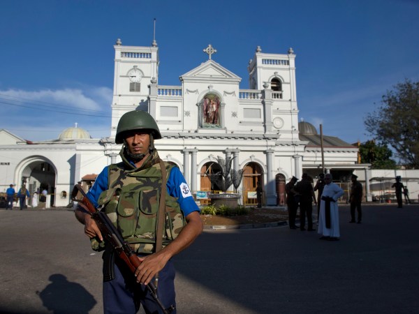 Sri Lankan air force officers and clergy stand outside St. Anthony's Shrine a day after a blast in Colombo, Sri Lanka, Monday, April 22, 2019. More than two hundred people were killed and hundreds more injured in eight blasts that rocked churches and hotels in and just outside Sri Lanka's capital on Easter Sunday.(AP Photo/Gemunu Amarasinghe)