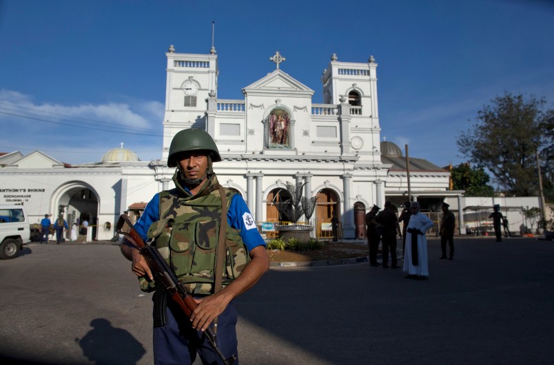Sri Lankan air force officers and clergy stand outside St. Anthony's Shrine a day after a blast in Colombo, Sri Lanka, Monday, April 22, 2019. More than two hundred people were killed and hundreds more injured in eight blasts that rocked churches and hotels in and just outside Sri Lanka's capital on Easter Sunday.(AP Photo/Gemunu Amarasinghe)