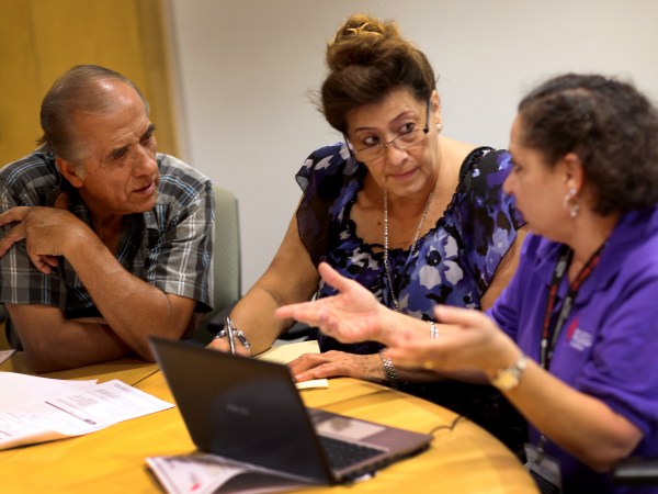 MIAMI, FL - OCTOBER 08:  Affordable Care Act navigator Nini Hadwen (R) speaks with Jorge Hernandez (L) and Marta Aguirre as they shop for health insurance during a navigation session put on by the Epilepsy Foundation Florida to help people sign up for health insurance under the Affordable Care Act on October 8, 2013 in Miami, Florida. The United States government continues to be partially shut down as Republicans hold out hope to cut funding for the Affordable Care Act.  (Photo by Joe Raedle/Getty Images)