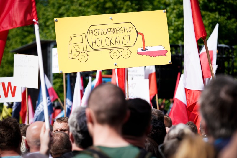 A sign is seen during the protest against the JUST act in Warsaw, Poland on May 11, 2019. Several thousand people gathered in front of the Prime Minister's office and marched to the US embassy to protest the Justice for Uncompensated Survivors Today (JUST) act 447 which requires the US State Department to report on progress made by 47 countries on compensation of assests seized during WWII for Holocaust survivors. Poland is the only European country that has not yet passed any laws to regulate compensation for rightful owners of seized properties. (Photo by Jaap Arriens/NurPhoto)