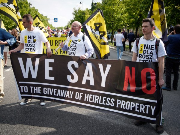 People hold a banner during a protest against the JUST act in Warsaw, Poland on May 11, 2019. Several thousand people gathered in front of the Prime Minister's office and marched to the US embassy to protest the Justice for Uncompensated Survivors Today (JUST) act 447 which requires the US State Department to report on progress made by 47 countries on compensation of assests seized during WWII for Holocaust survivors. Poland is the only European country that has not yet passed any laws to regulate compensation for rightful owners of seized properties. (Photo by Jaap Arriens/NurPhoto)