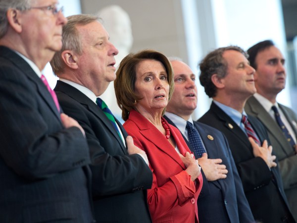 UNITED STATES - APRIL 15: From left, Senate Majority Leader Mitch McConnell, R-Ky., Senate Minority Whip Richard Durbin, D-Ill., House Minority Leader Nancy Pelosi, House Majority Whip Steve Scalise, R-La., Sen. Sherrod Brown, D-Ohio, and Rep. Pete Olson, R-Texas, sing the National Anthem during a Congressional Gold Medal ceremony to honor the to the Doolittle Tokyo Raiders in the Capitol Visitor Center's Emancipation Hall, April 15, 2015. (Photo By Tom Williams/CQ Roll Call)