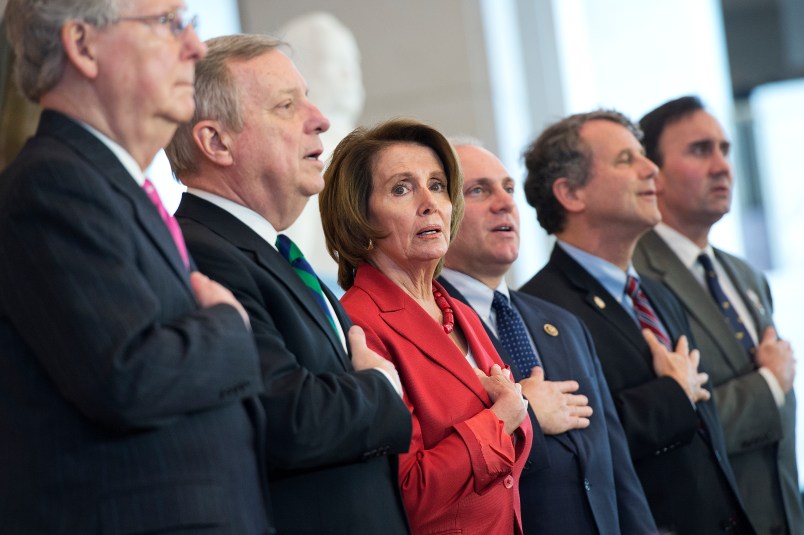 UNITED STATES - APRIL 15: From left, Senate Majority Leader Mitch McConnell, R-Ky., Senate Minority Whip Richard Durbin, D-Ill., House Minority Leader Nancy Pelosi, House Majority Whip Steve Scalise, R-La., Sen. Sherrod Brown, D-Ohio, and Rep. Pete Olson, R-Texas, sing the National Anthem during a Congressional Gold Medal ceremony to honor the to the Doolittle Tokyo Raiders in the Capitol Visitor Center's Emancipation Hall, April 15, 2015. (Photo By Tom Williams/CQ Roll Call)