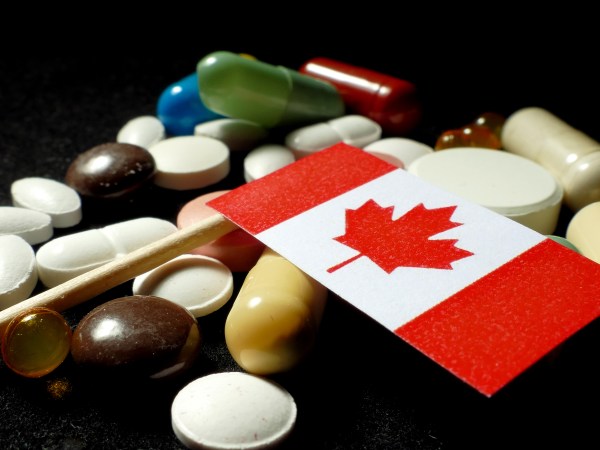 Canadian flag with lot of medical pills isolated on black background