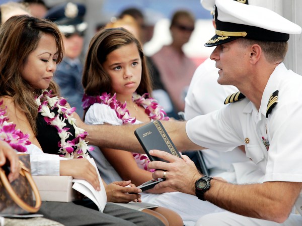 PEARL HARBOR, HI - JULY 11:  During a memorial service held at the National Memorial Cemetery of the Pacific in Honolulu, Naval Rear Admiral Joseph Maguire, Commander of the Naval Special Warfare Command (right) presents an award post humorously to Norminda Healy, wife of Daniel Richard Healy, a navy SEAL killed in action while conducting combat operations in Afghanistan, July 11, 2005.   (Photo by Marco Garcia/Getty Images)