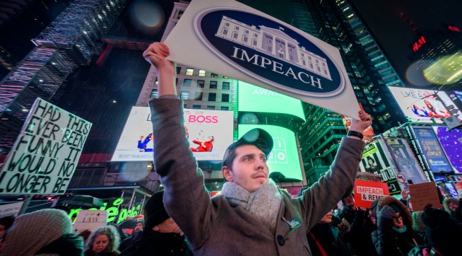 NEW YORK, UNITED STATES - 2019/12/17: Protester holding a sign at the rally in Times Square. The night before the House of Representatives takes a somber vote to impeach Trump, hundreds of thousands of Americans joined the "Nobody Is Above the Law" coalition at more than 500 rallies planned around the country, calling on the U.S. House to vote to impeach President Donald Trump. In New York City thousands of protesters took to the streets, gathering at Father Duffy Square in Times Square, and marched down Broadway to Union Square. (Photo by Erik McGregor/LightRocket via Getty Images)