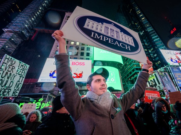 NEW YORK, UNITED STATES - 2019/12/17: Protester holding a sign at the rally in Times Square. The night before the House of Representatives takes a somber vote to impeach Trump, hundreds of thousands of Americans joined the "Nobody Is Above the Law" coalition at more than 500 rallies planned around the country, calling on the U.S. House to vote to impeach President Donald Trump. In New York City thousands of protesters took to the streets, gathering at Father Duffy Square in Times Square, and marched down Broadway to Union Square. (Photo by Erik McGregor/LightRocket via Getty Images)
