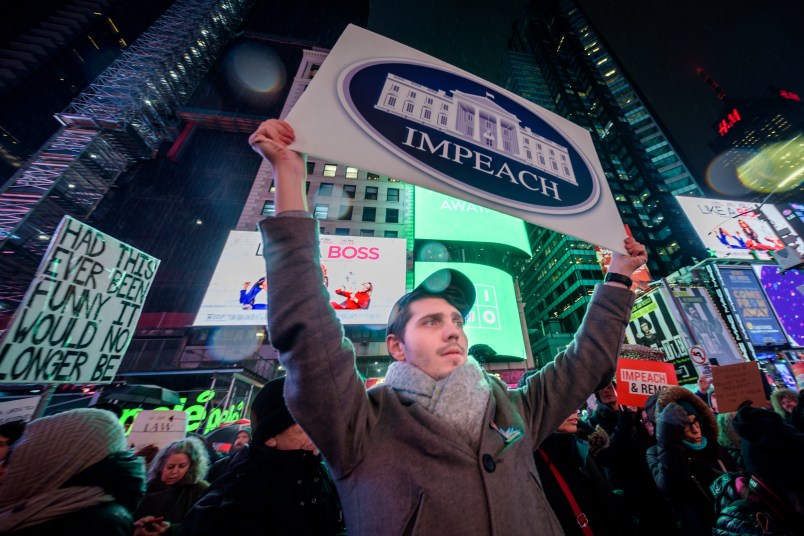 NEW YORK, UNITED STATES - 2019/12/17: Protester holding a sign at the rally in Times Square. The night before the House of Representatives takes a somber vote to impeach Trump, hundreds of thousands of Americans joined the "Nobody Is Above the Law" coalition at more than 500 rallies planned around the country, calling on the U.S. House to vote to impeach President Donald Trump. In New York City thousands of protesters took to the streets, gathering at Father Duffy Square in Times Square, and marched down Broadway to Union Square. (Photo by Erik McGregor/LightRocket via Getty Images)
