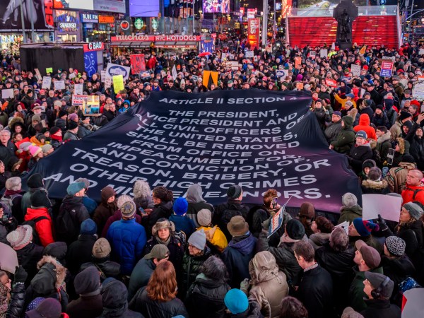 NEW YORK, UNITED STATES - 2019/12/17: Protester holding a giant banner with impeacment articles at the rally in Times Square. The night before the House of Representatives takes a somber vote to impeach Trump, hundreds of thousands of Americans joined the "Nobody Is Above the Law" coalition at more than 500 rallies planned around the country, calling on the U.S. House to vote to impeach President Donald Trump. In New York City thousands of protesters took to the streets, gathering at Father Duffy Square in Times Square, and marched down Broadway to Union Square. (Photo by Erik McGregor/LightRocket via Getty Images)