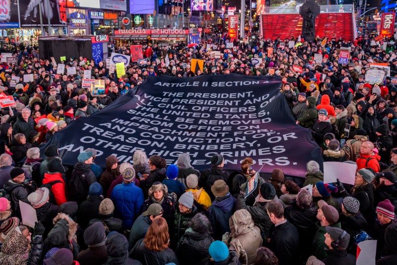 NEW YORK, UNITED STATES - 2019/12/17: Protester holding a giant banner with impeacment articles at the rally in Times Square. The night before the House of Representatives takes a somber vote to impeach Trump, hundreds of thousands of Americans joined the "Nobody Is Above the Law" coalition at more than 500 rallies planned around the country, calling on the U.S. House to vote to impeach President Donald Trump. In New York City thousands of protesters took to the streets, gathering at Father Duffy Square in Times Square, and marched down Broadway to Union Square. (Photo by Erik McGregor/LightRocket via Getty Images)