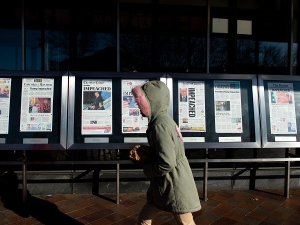 UNITED STATES - DECEMBER 19: A person walks by the newspaper front pages, from around the US, on display at the Newseum the day after the House of Representatives passed two articles of impeachment against President Donald Trump on Thursday Dec. 19, 2019. (Photo by Caroline Brehman/CQ Roll Call)