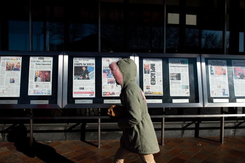 UNITED STATES - DECEMBER 19: A person walks by the newspaper front pages, from around the US, on display at the Newseum the day after the House of Representatives passed two articles of impeachment against President Donald Trump on Thursday Dec. 19, 2019. (Photo by Caroline Brehman/CQ Roll Call)