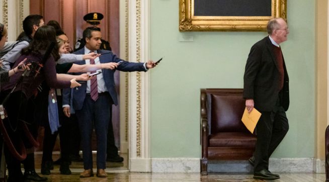 WASHINGTON, DC - JANUARY 30: Reporters reach out with their cell phones and audio recorders trying to get a statement from Sen. Lamar Alexander (R-TN) as he passes by during a recess in the Senate impeachment trial of President Donald Trump on January 30, 2020 in Washington, DC. The trial has entered into the second day of the question phase where Senators have the opportunity to submit written questions to the House managers and President Trump's defense team. (Photo by Samuel Corum/Getty Images) *** Local Caption *** Lamar Alexander