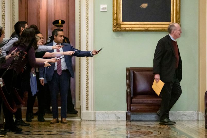 WASHINGTON, DC - JANUARY 30: Reporters reach out with their cell phones and audio recorders trying to get a statement from Sen. Lamar Alexander (R-TN) as he passes by during a recess in the Senate impeachment trial of President Donald Trump on January 30, 2020 in Washington, DC. The trial has entered into the second day of the question phase where Senators have the opportunity to submit written questions to the House managers and President Trump's defense team. (Photo by Samuel Corum/Getty Images) *** Local Caption *** Lamar Alexander