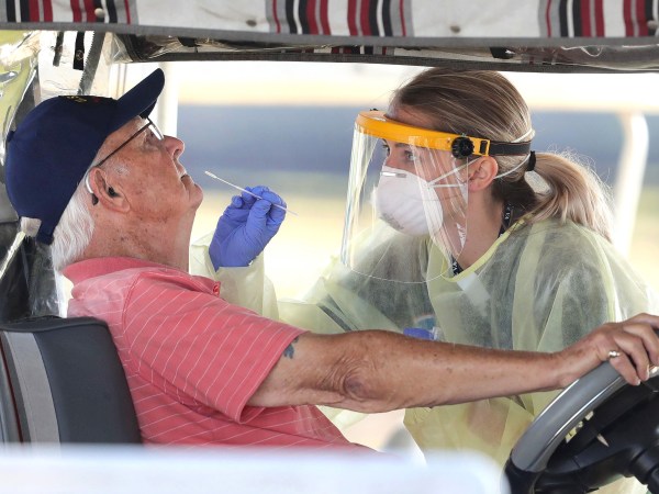 A resident of The Villages, Fla. gets tested for the coronavirus with a nasal swab at a drive-through site that accomodates golf carts, at The Villages Polo Club, Monday, March 23, 2020. The testing site is being operated by UF Health, with University of Florida medical students performing the tests, and is limited to residents of The Villages only. (Joe Burbank/Orlando Sentinel/TNS)