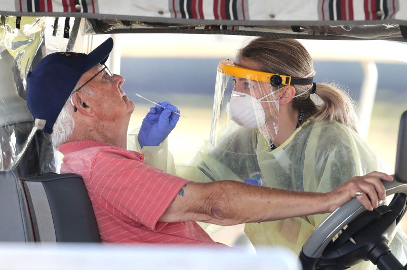 A resident of The Villages, Fla. gets tested for the coronavirus with a nasal swab at a drive-through site that accomodates golf carts, at The Villages Polo Club, Monday, March 23, 2020. The testing site is being operated by UF Health, with University of Florida medical students performing the tests, and is limited to residents of The Villages only. (Joe Burbank/Orlando Sentinel/TNS)