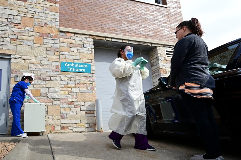 Fridley, MN March 10: M Health Fairview Medical Assistants Reece Wallaker, center, and Sandy Graves, administered a COVID-19 test to an actor and fellow Fairview employee, Nichole Brown, outside the M Health Fairview Fridley clinic Tuesday. (Photo by Aaron Lavinsky/Star Tribune via Getty Images)