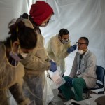 NEW YORK, NY - MARCH 24:  Doctors test hospital staff with flu-like symptoms for COVID-19. St. Barnabas hospital in the Bronx set-up tents to triage possible COVID-19 patients outside before they enter the main Emergency department area on March 24, 2020 in New York City. (Photo by Misha Friedman/Getty Images)