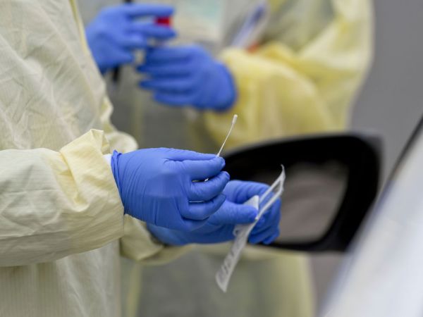 A detail photo of a nasal swab held by a Registered Nurse wearing gloves and a protective gown that she is about to use to do a test on a patient in their car at Penn State Health St. Joseph where they are conducting drive through coronavirus / COVID-19 testing and have taken extra precautions regarding entry to the hospital,  in Bern Township, PA Friday afternoon March 27, 2020.