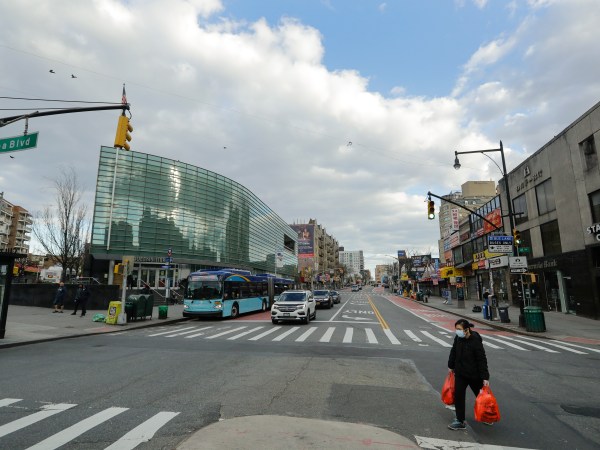 A woman wearing personal protective equipment crosses Main Street Wednesday, April 1, 2020, in the Flushing section of the Queens borough of New York. The new coronavirus causes mild or moderate symptoms for most people, but for some, especially older adults and people with existing health problems, it can cause more severe illness or death. (AP Photo/Frank Franklin II)
