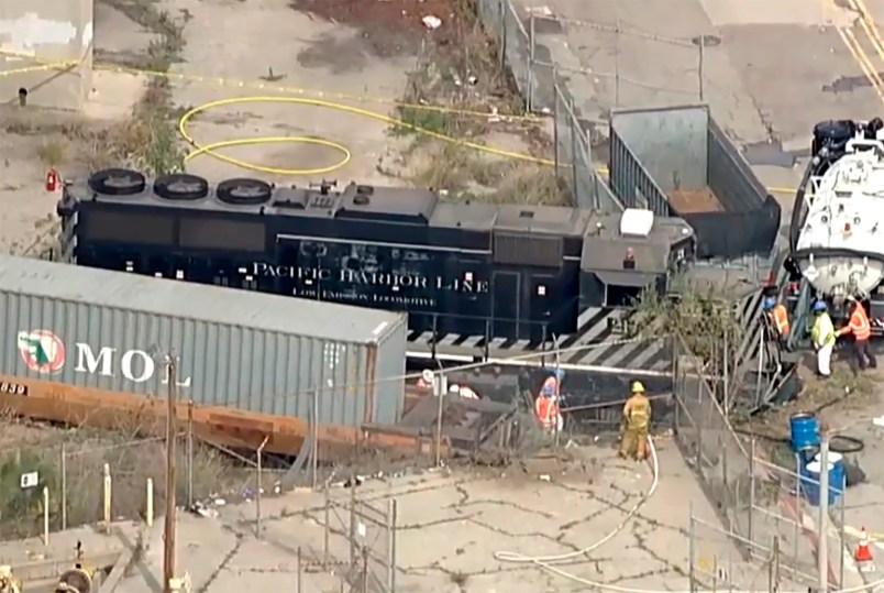 This image taken from video provided by KABC-TV shows a Pacific Harbor Line train that derailed Tuesday, March 31, 2020, at the  Port of Los Angeles after running through the end of the track and crashing through barriers, finally coming to rest about 250 yards from the docked naval ship. The train engineer intentionally drove the speeding locomotive off a track at the Port of Los Angeles because he was suspicious about the presence of a Navy hospital ship docked there amid the coronovirus crisis. (KABC-TV via AP)